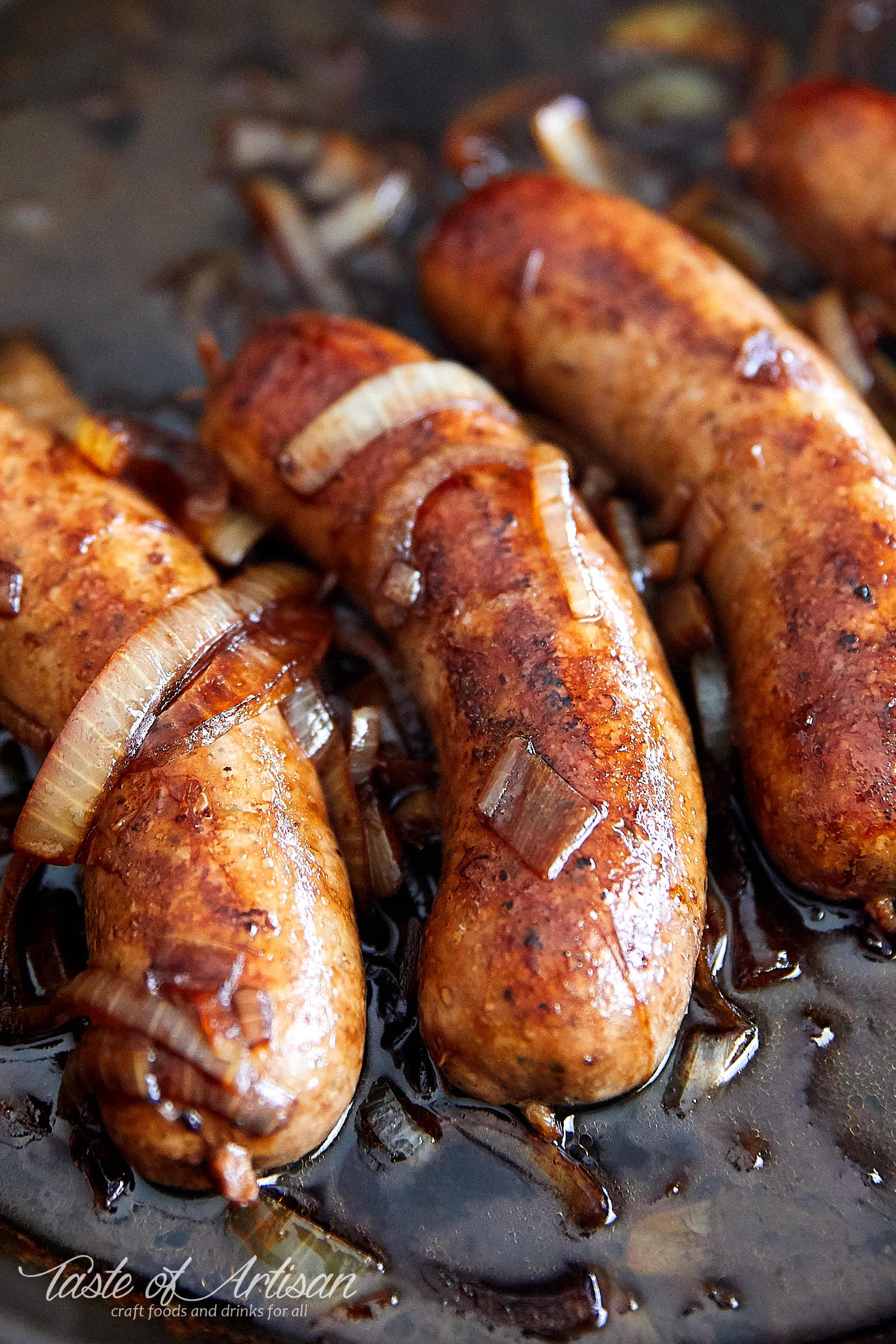 Homemade German Bratwurst frying in a pan.