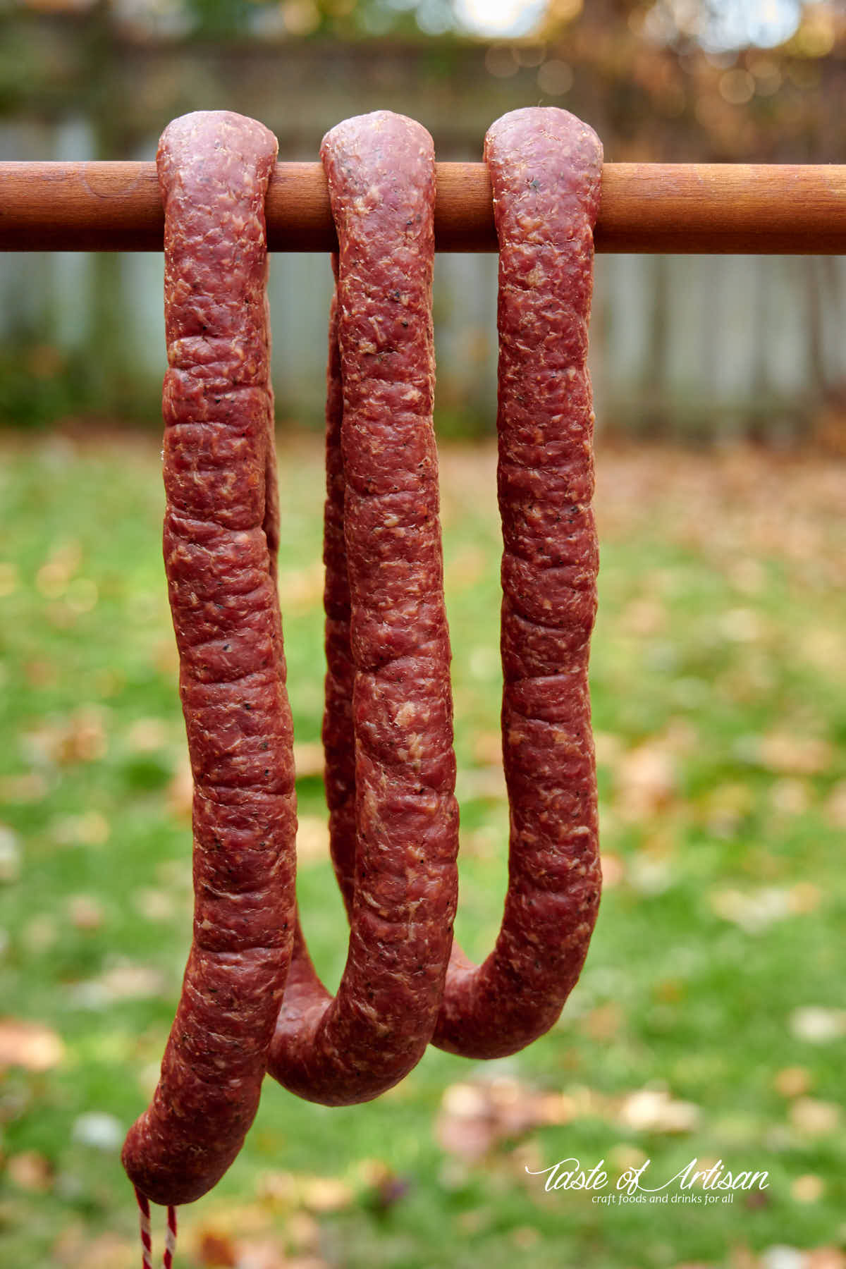 Dried smoked kielbasa on a smoke stick. 