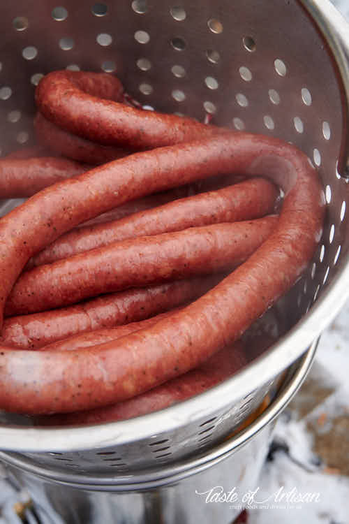 Smoked kielbasa in a basket after poaching.