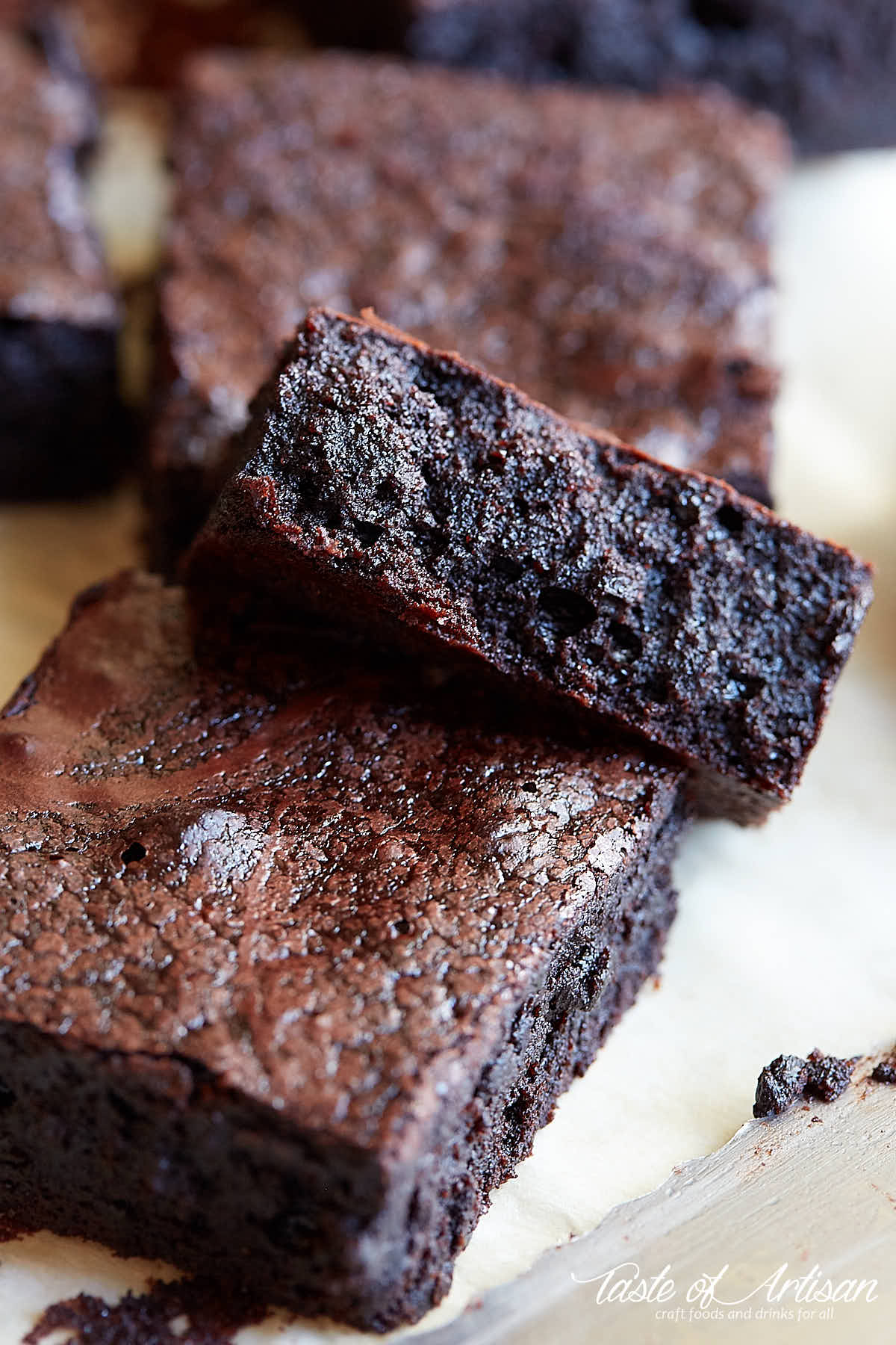 Flourless brownies, cut into pieces, set on a piece of paper.