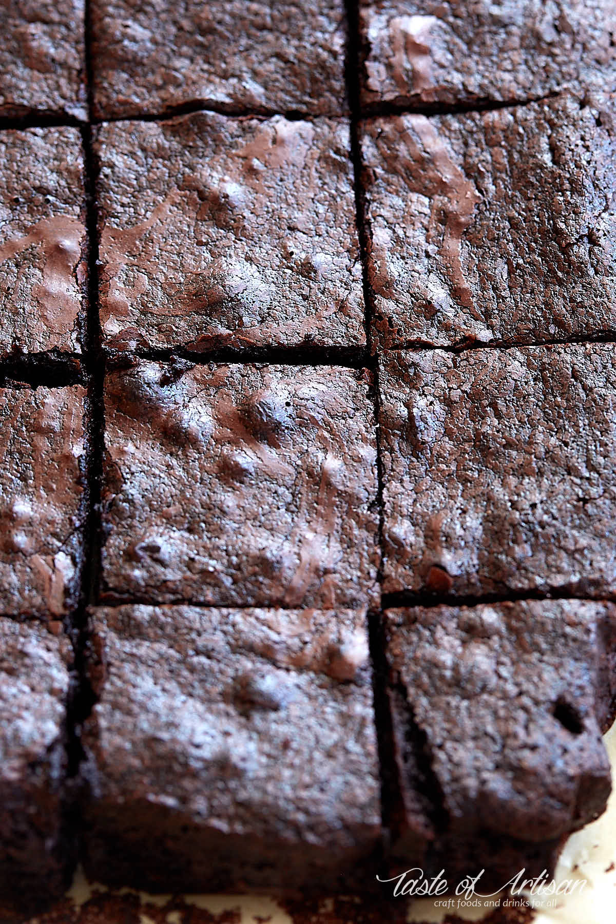 Flourless brownie, cut into squares, inside a baking dish.