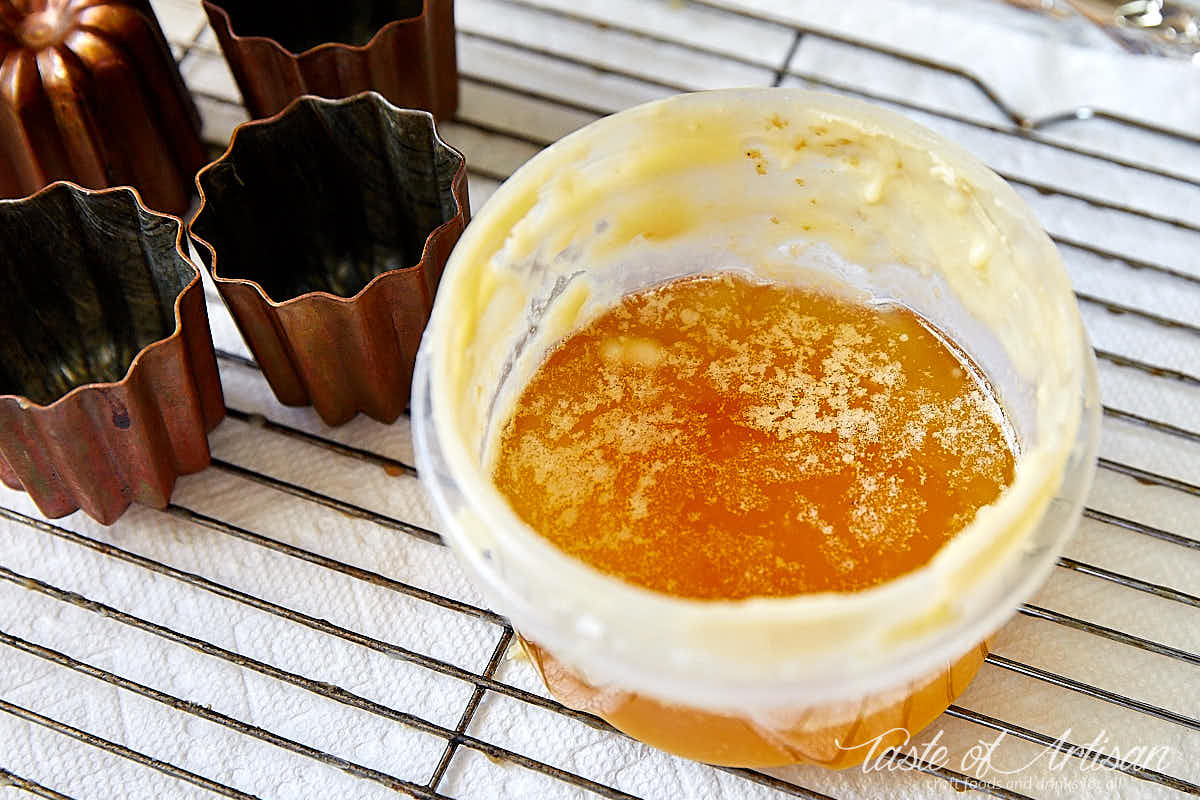 Beeswax and butter mix in a plastic bowl ready to be used to coat canele molds.