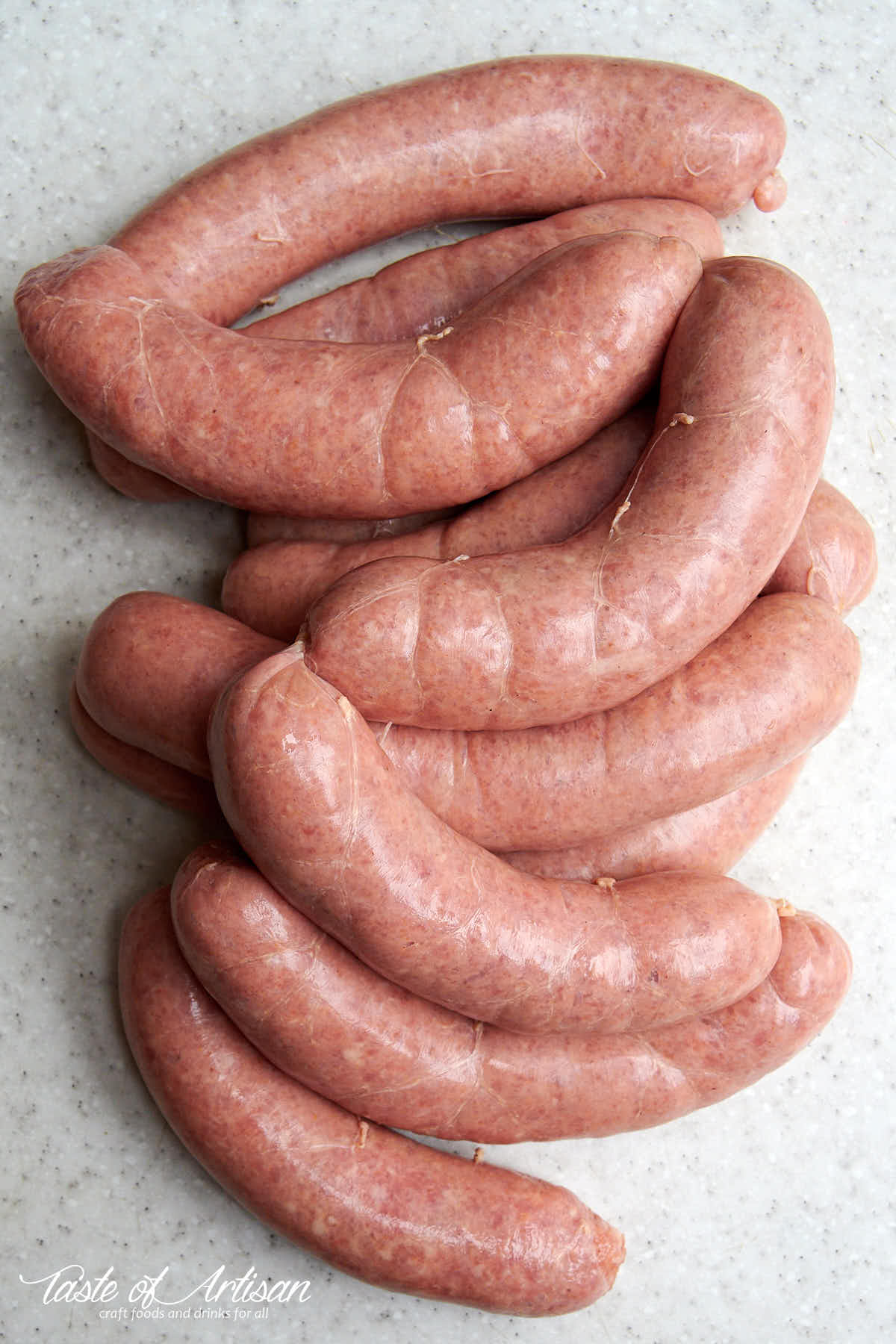 Raw Bockwurst sausage links on a grey table surface.