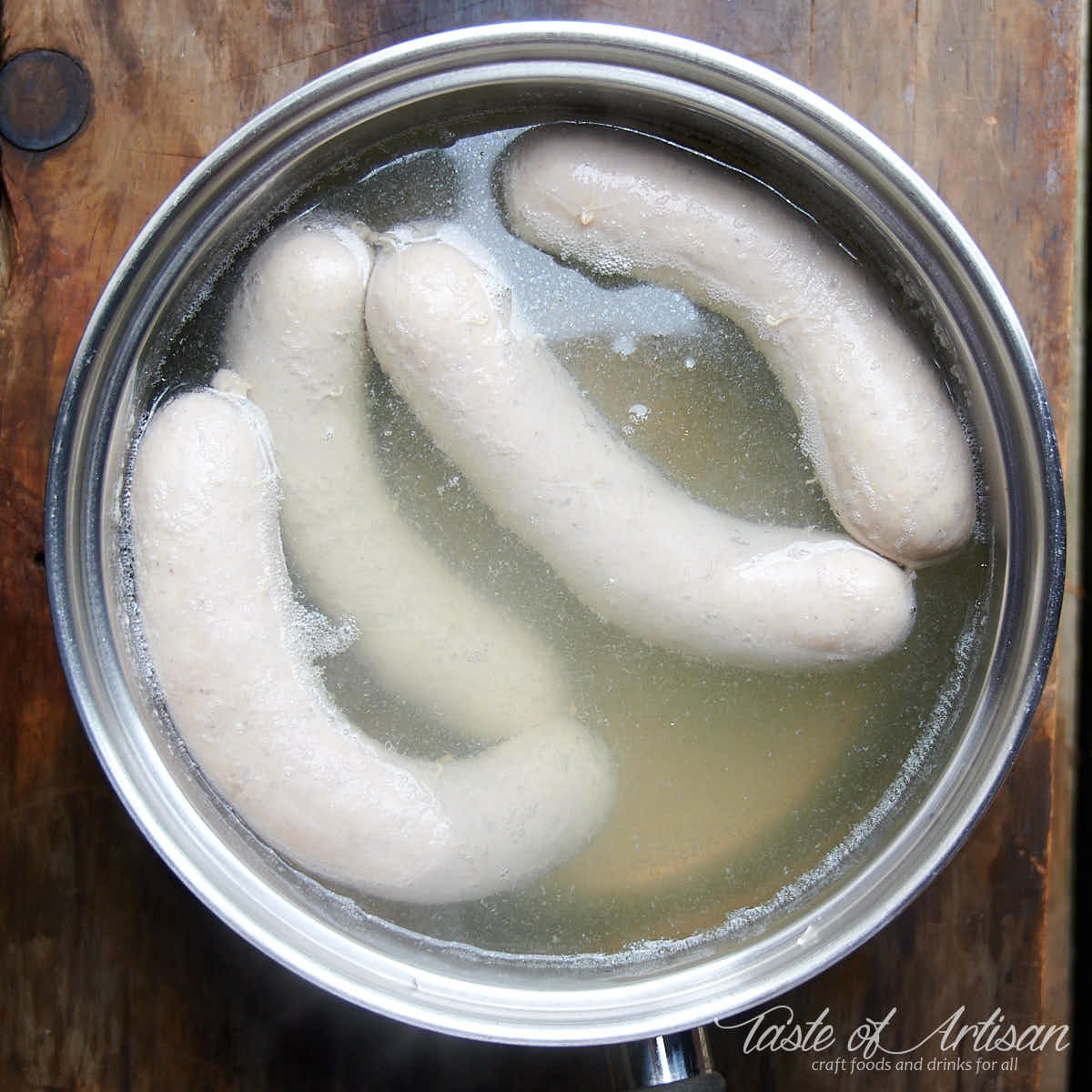 Bockwurst sausage poached in a pot of water.