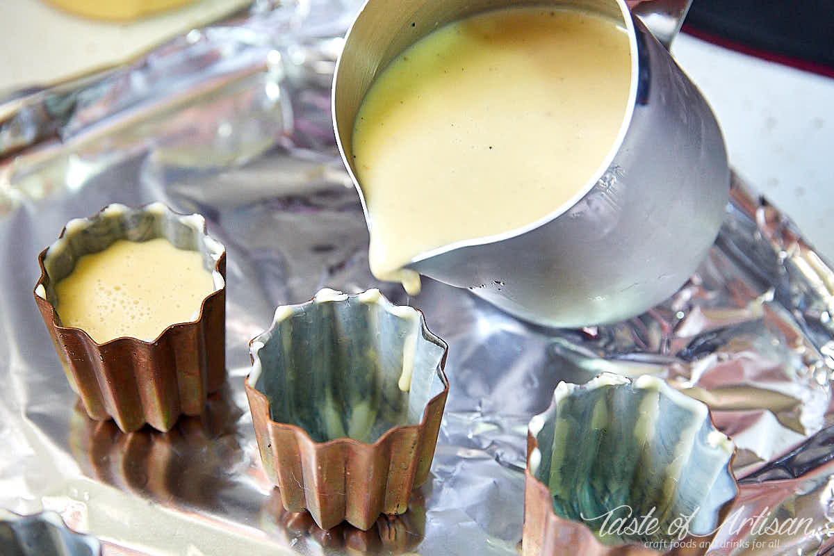 Pouring canele batter into a copper mold.