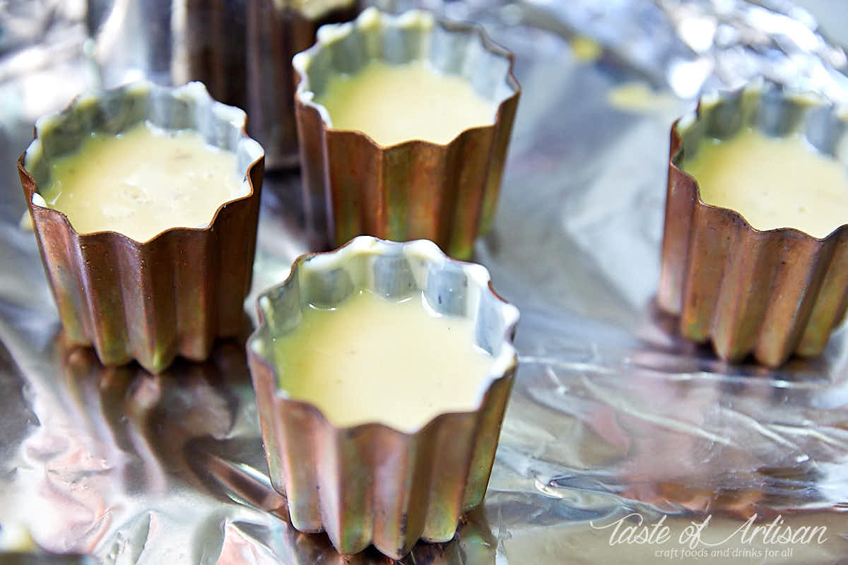 Copper molds filled with canele batter.