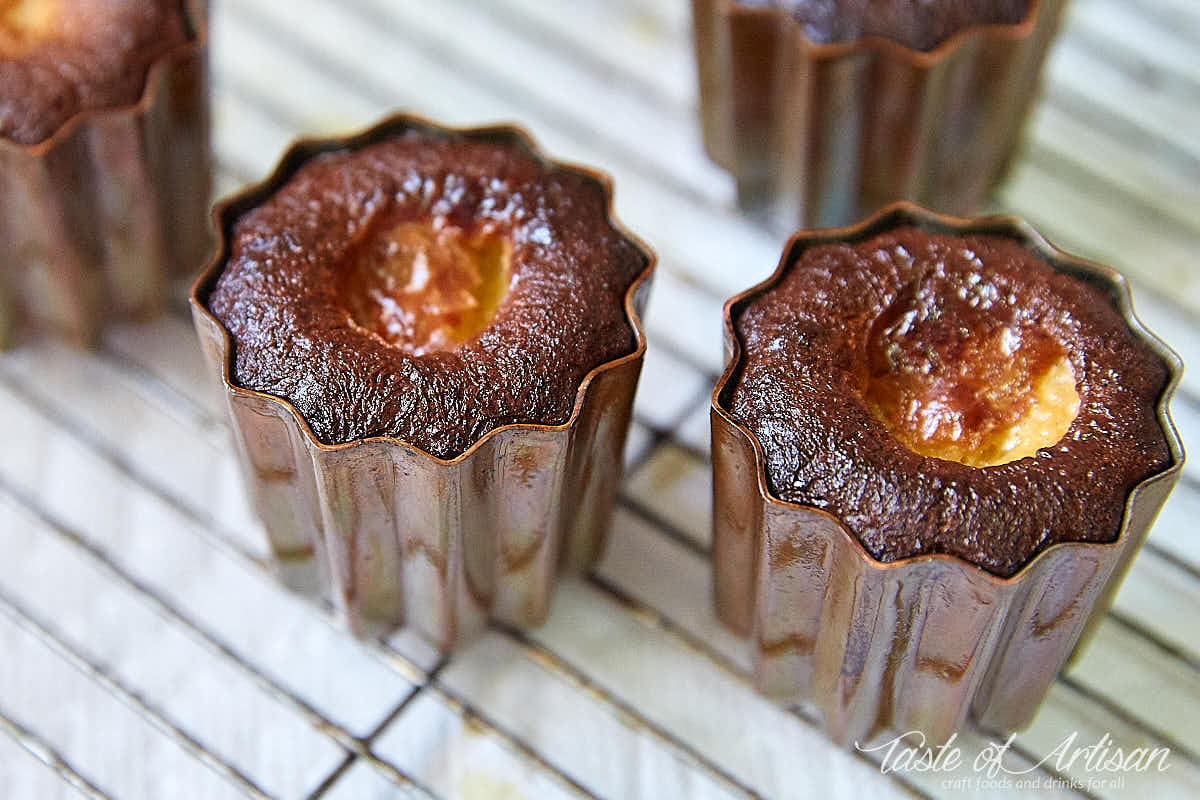 Crispy, dark brown caneles inside copper molds.