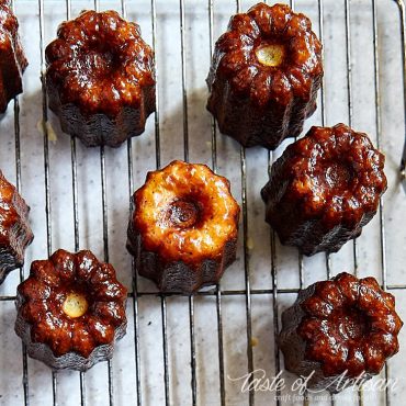 Caneles on a cooling rack, view at an angle.