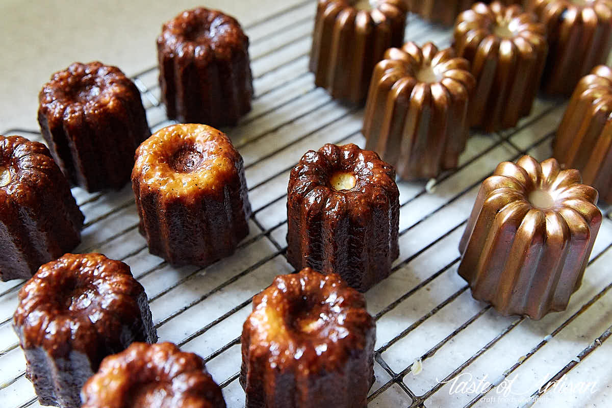 Caneles on a cooling rack, view at an angle.