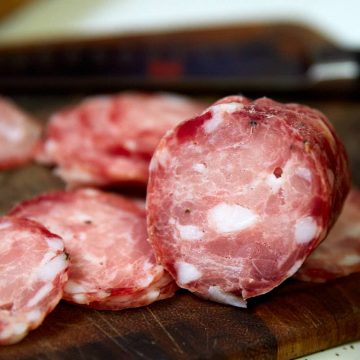 Sliced sopressata on a cutting board.