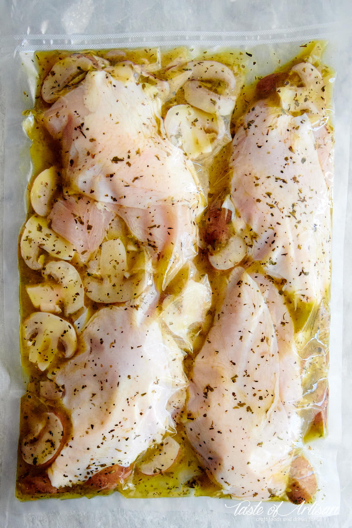 Chicken breasts with seasonings vacuum sealed in a bag, ready for sous vide cooking.