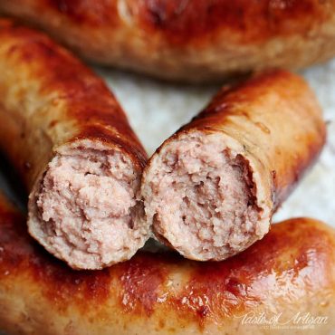 Close up of bockwurst snapped in half, showing pink, juicy meat.