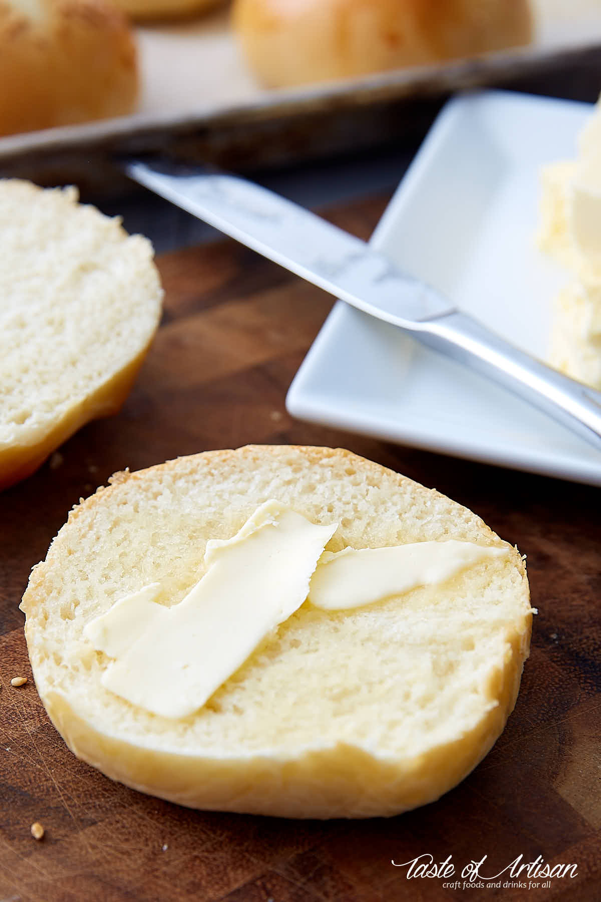 A cut in half brioche bun with butter spread on top.