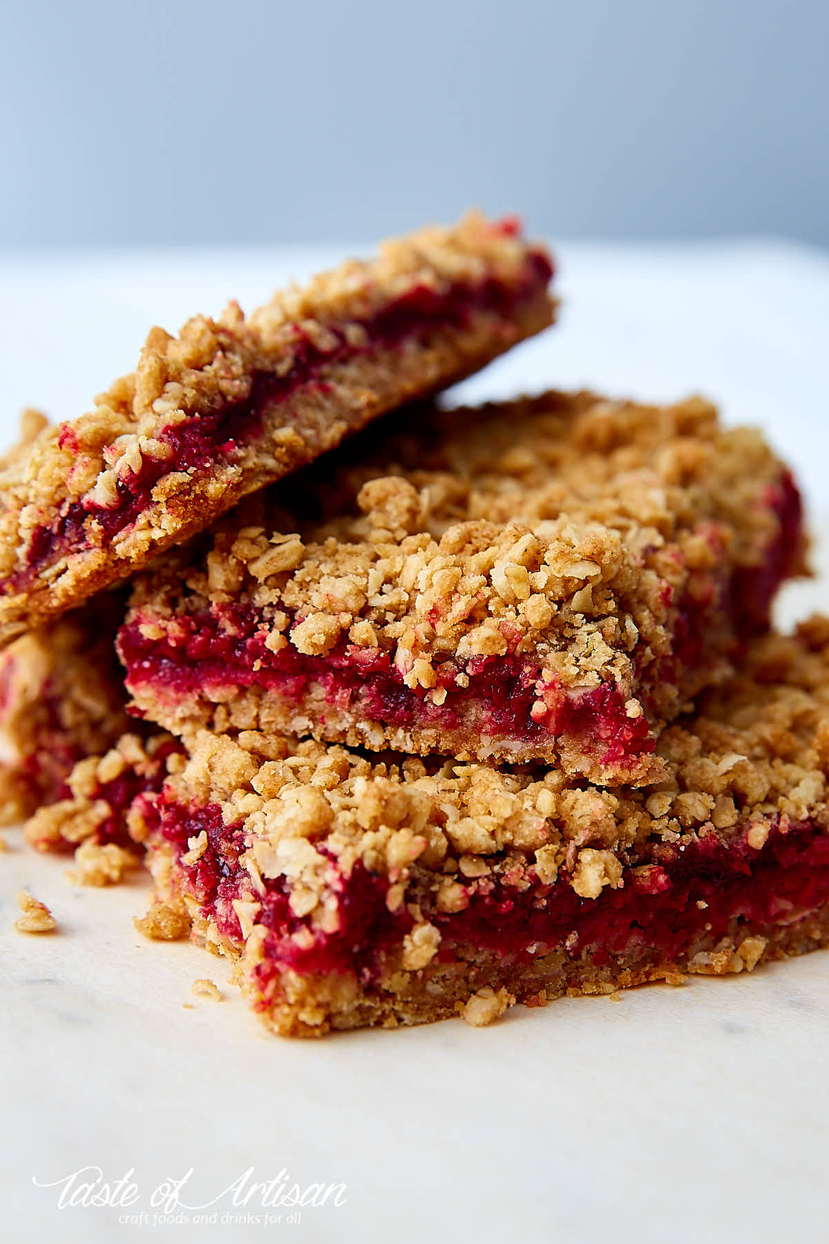 Cherry oat bars stacked on top each other on a table.