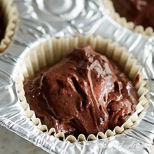 Chocolate cheery cupcake batter in a muffin tin.