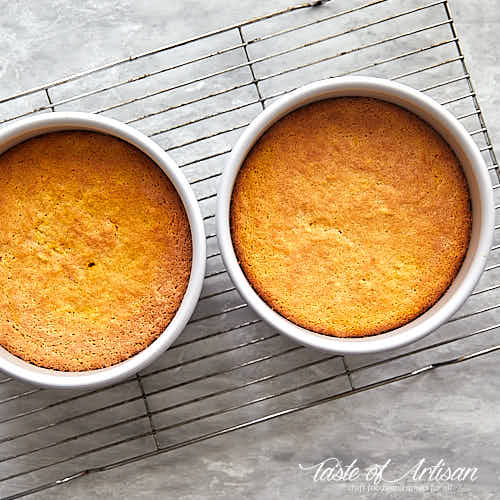 Two pans with baked carrot cake layers.