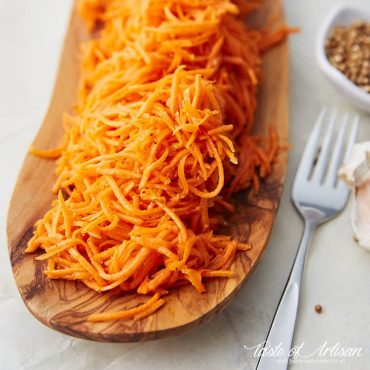 Marinated carrots on a wooden serving platter.