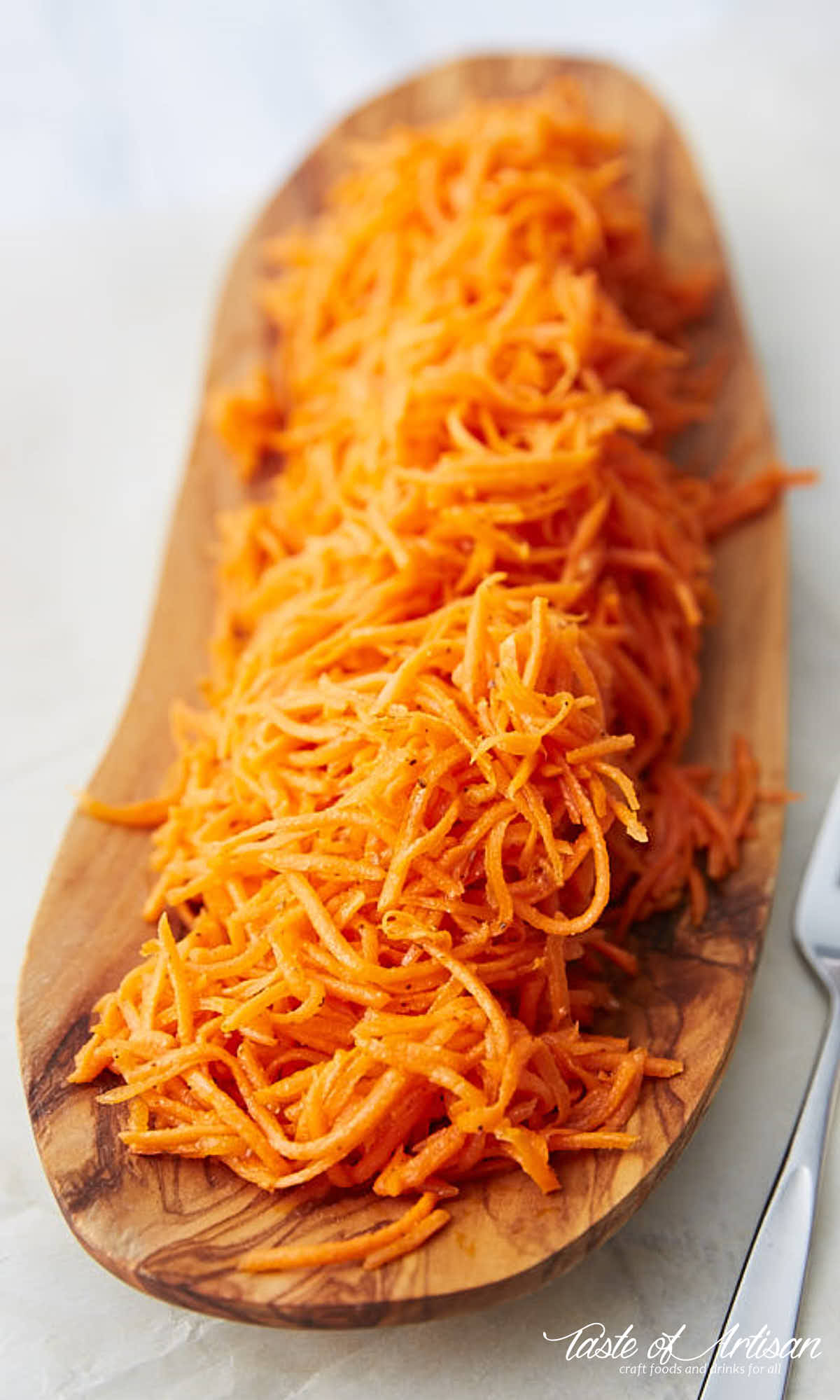 Marinated carrots on a wooden serving platter.