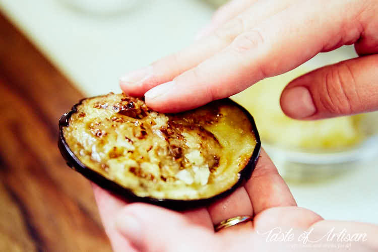 Spreading garlic on top of eggplant slice.