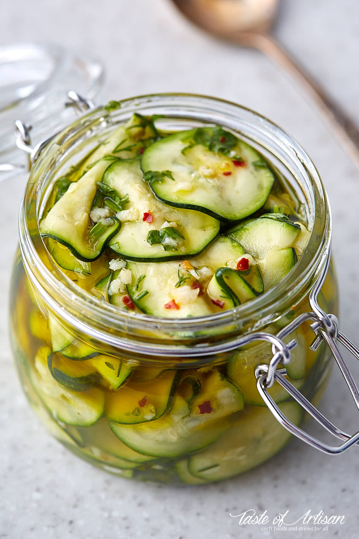 Sliced marinated zucchini in a glass jar.