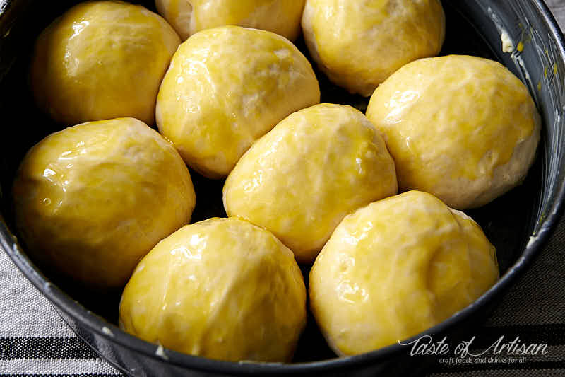 Pampushki dough balls brushed with egg yolk.