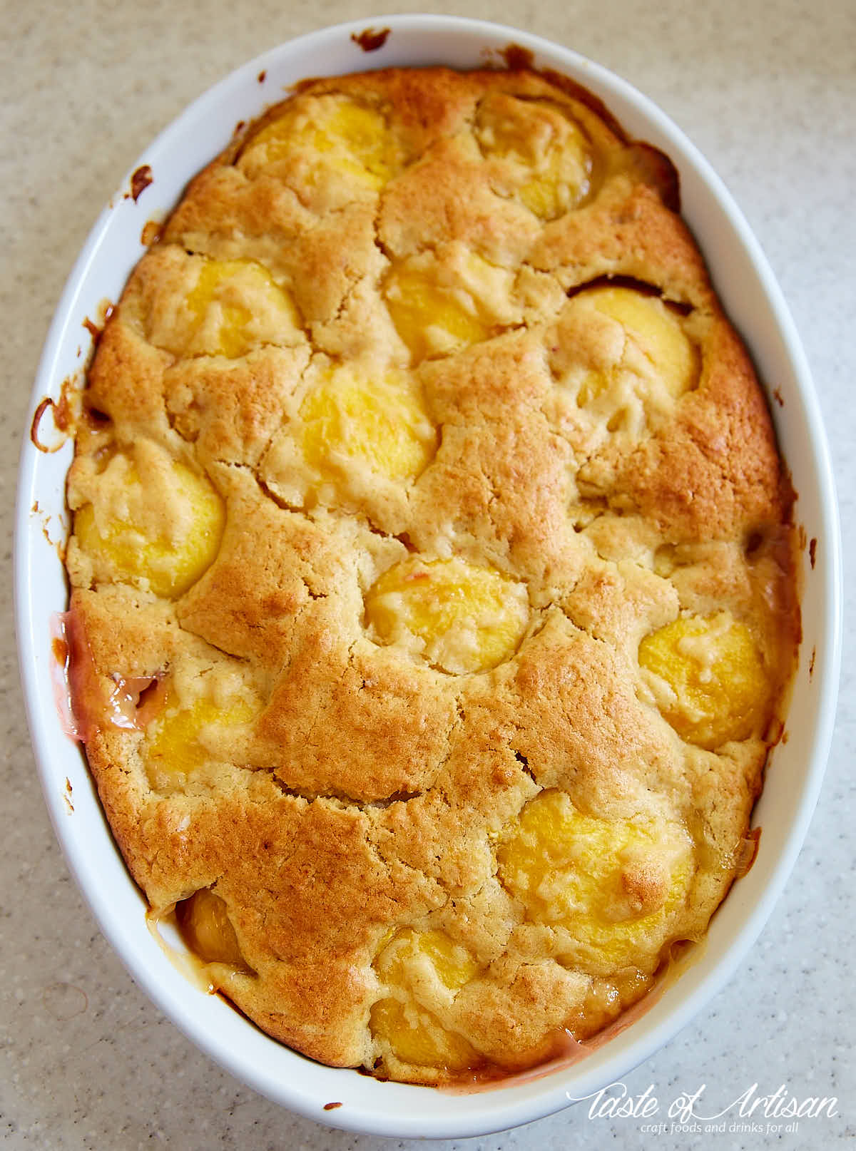 Baked peach dump cake in white baking dish.