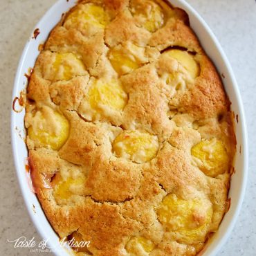 Baked peach dump cake in white baking dish.