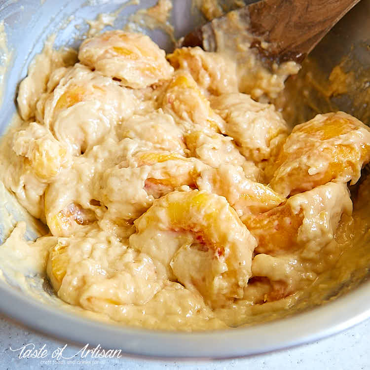 Peach dump cake ingredients mixed in a bowl.