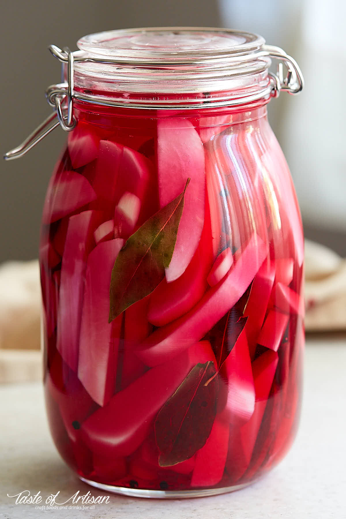 Turnips cut into pieces inside a jar filled with purple pickling juice.