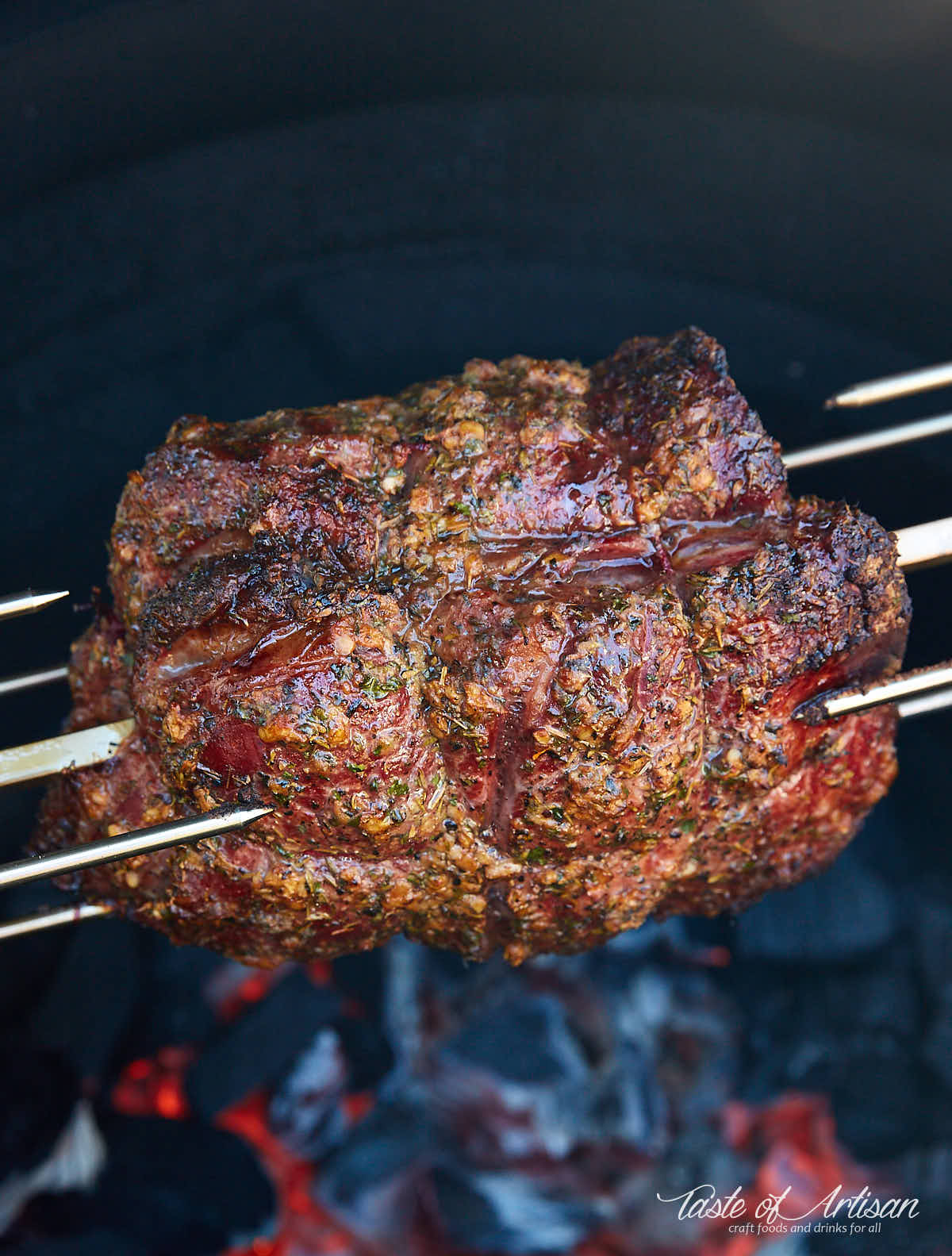 Rundbraten auf einem Rotisserie-Spieß über heißer Holzkohle.