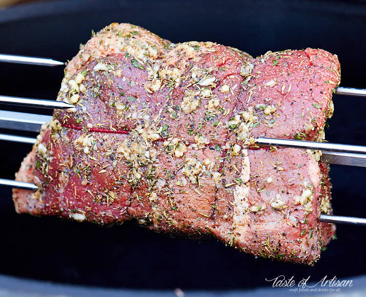 Roh gebratener Braten, mit Knoblauch und Kräutern auf einem Drehspieß gekrustet.