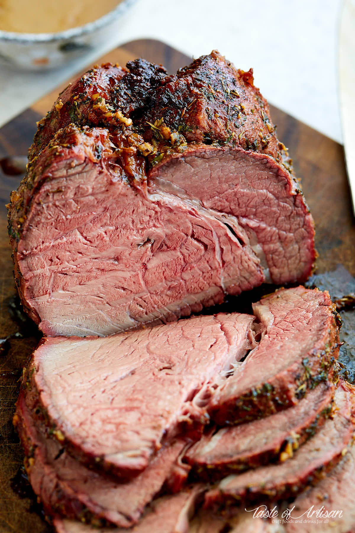 Top round roast sliced on a cutting board.