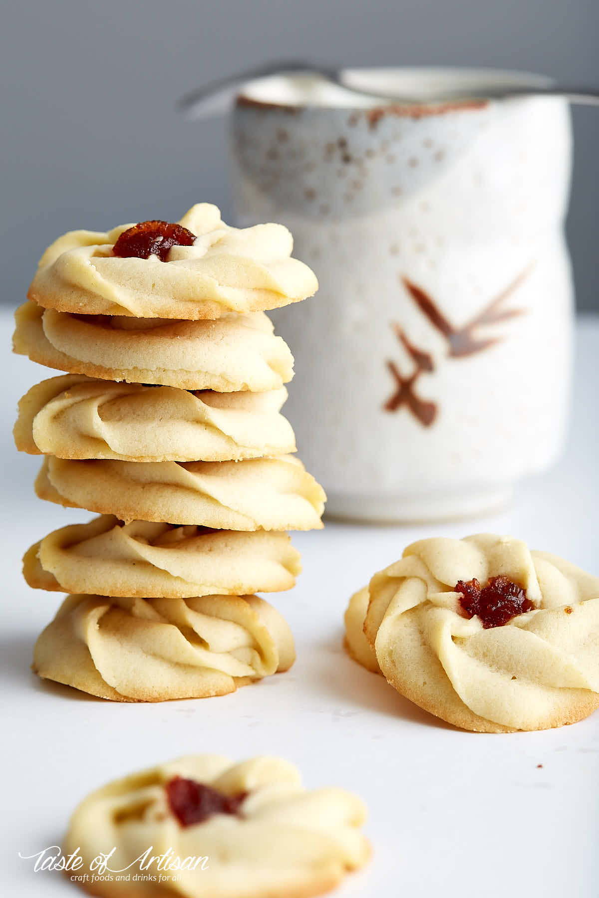 Shortbread cookies with jam on a white table.