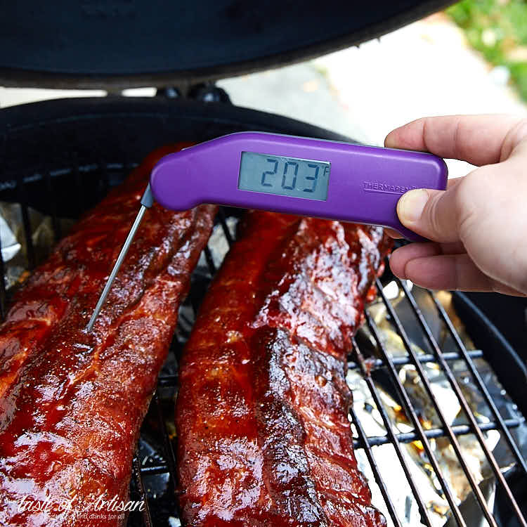 Checking baby back ribs with a thermometer.