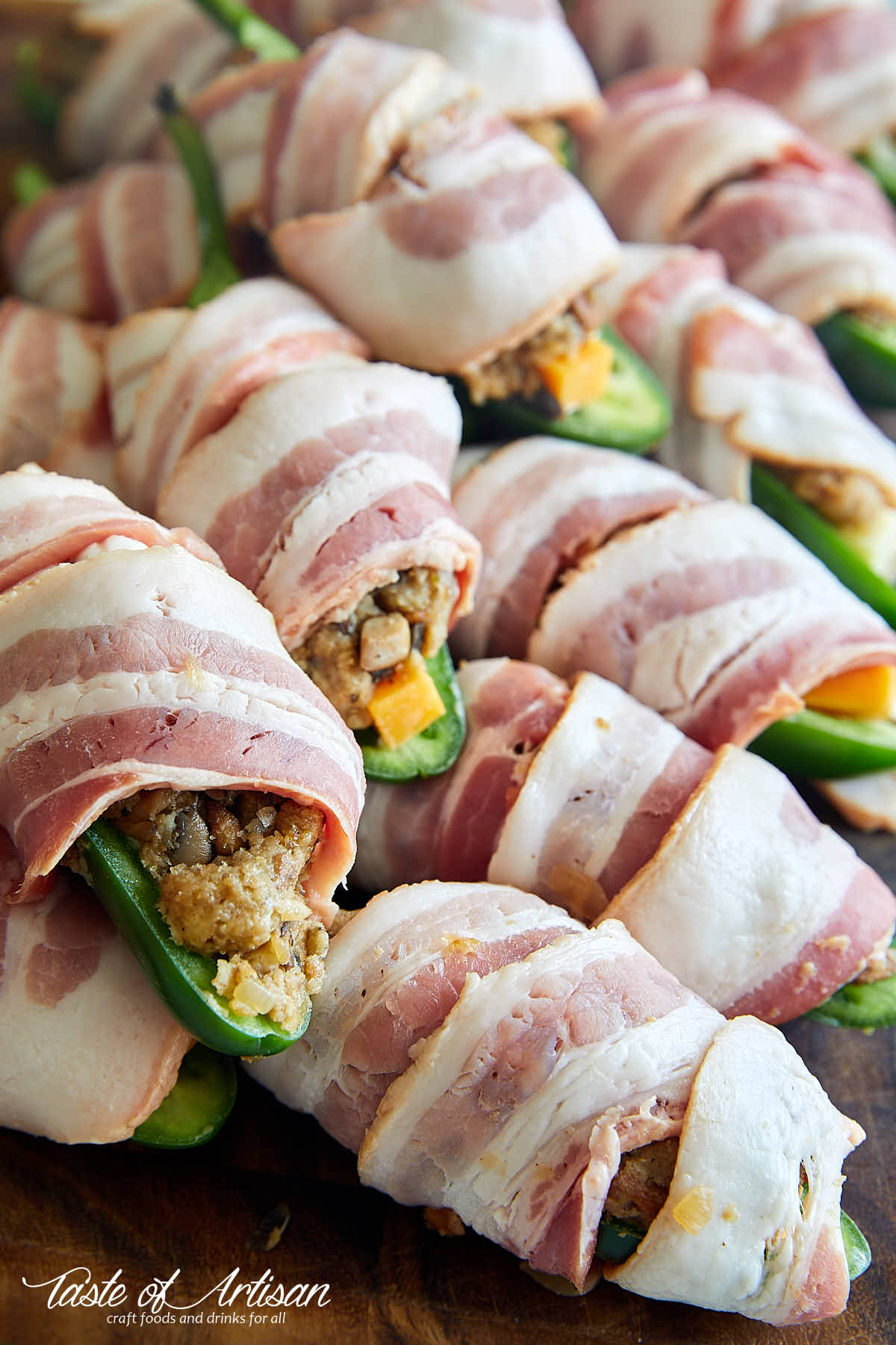 Raw jalapeno poppers, stuffed and wrapped in bacon, ready to be smoked.