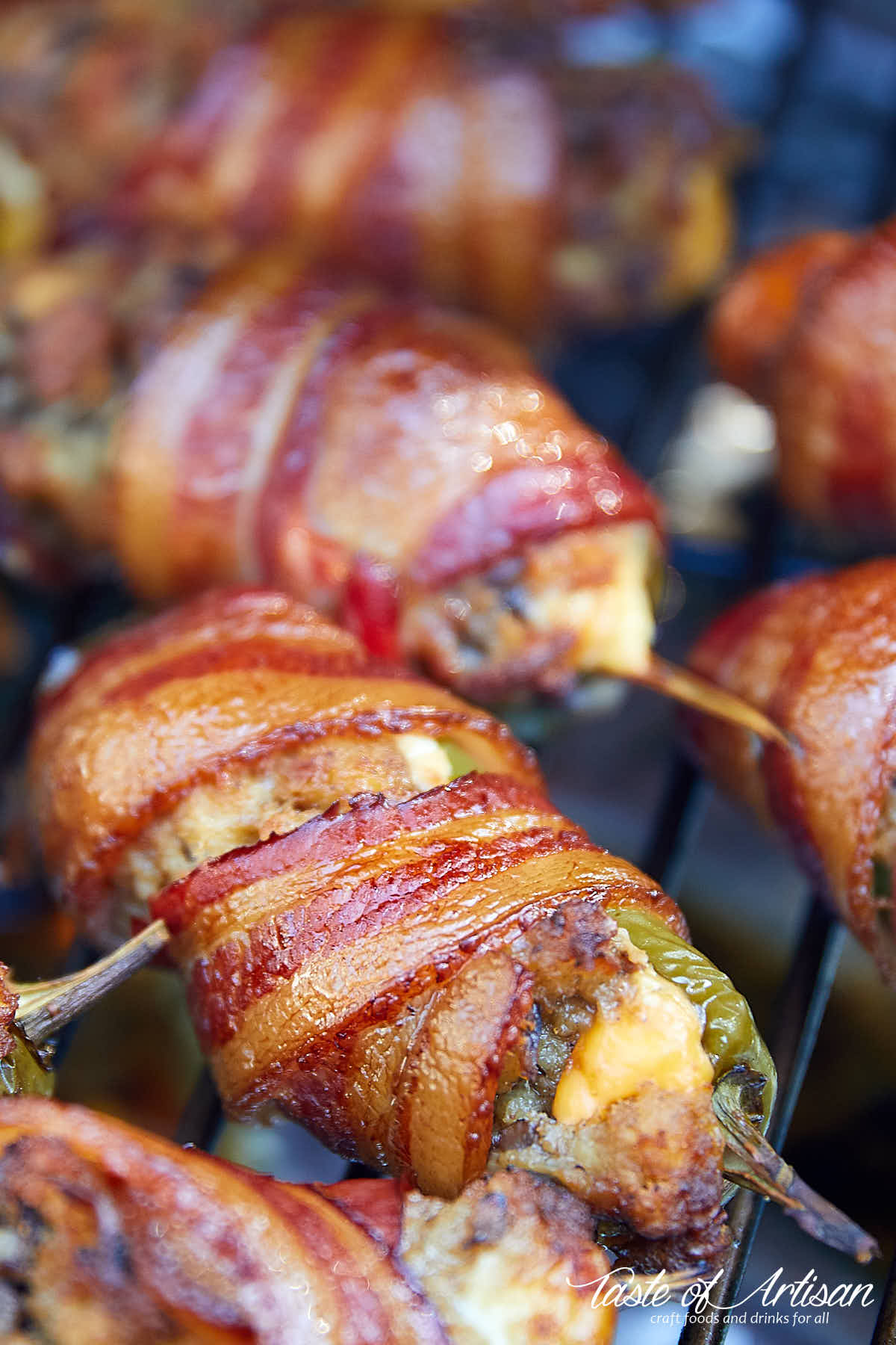 Jalapeno poppers, wrapped in bacon, inside a smoker.