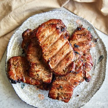 Smoked pork chops, deep brown, on a platter.