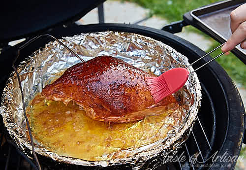 Brushing smoked turkey breast with buttery juices.