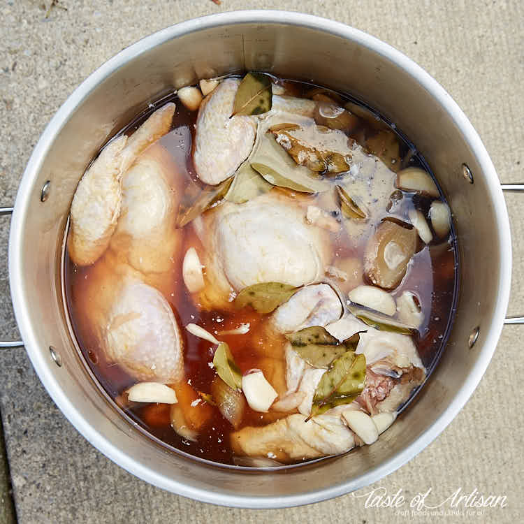 Whole chickens inside a pot with brine.