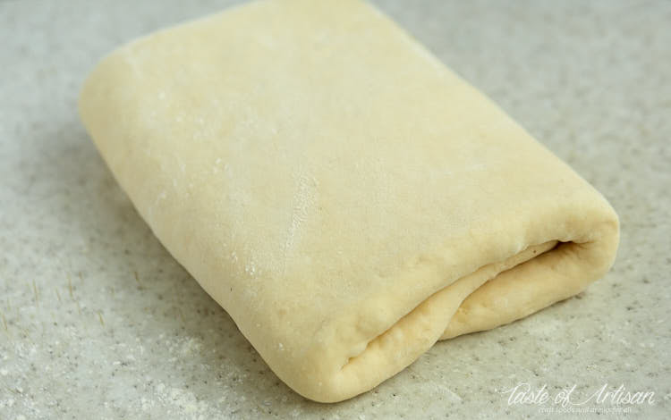 Dough folded with butter inside. Croissant dough lamination.