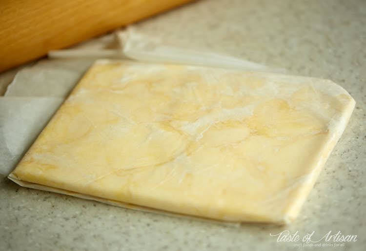 Flattened butter in a parchment paper envelope.