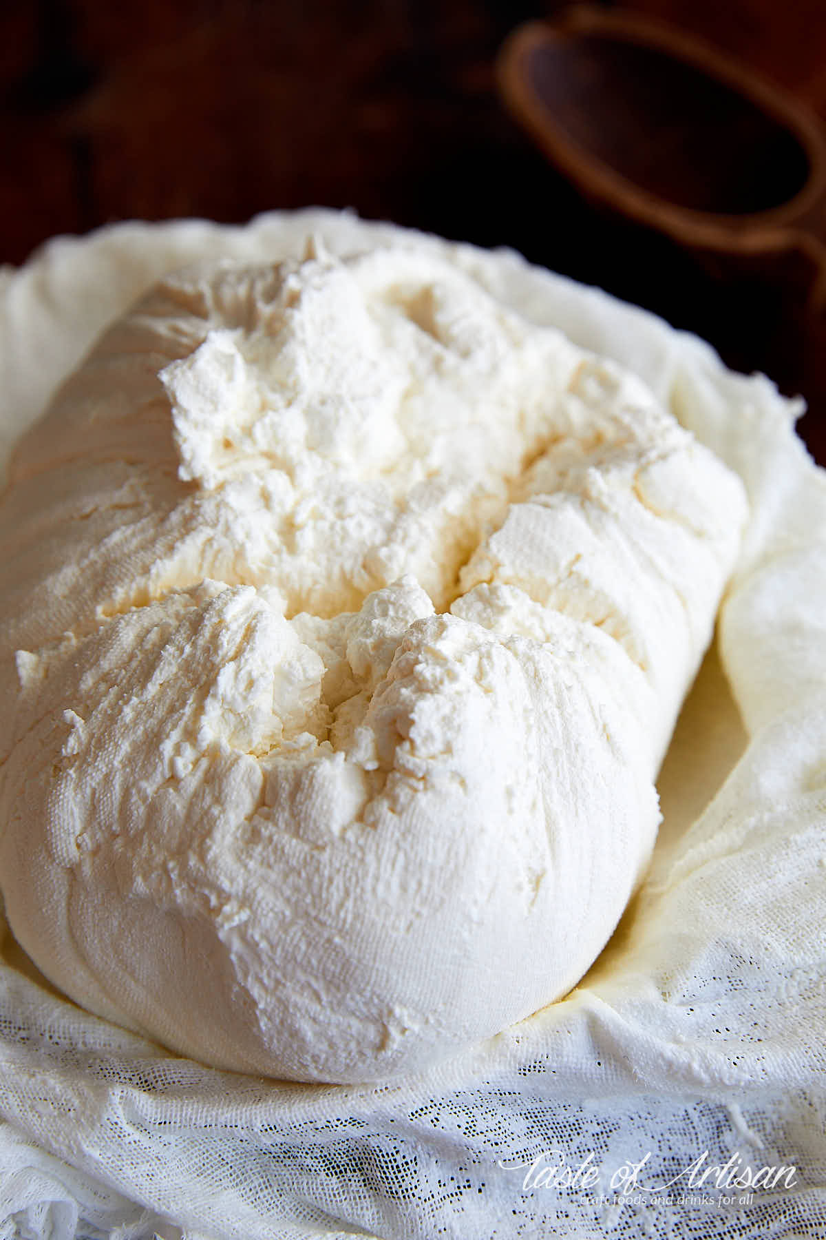 A bowl lined with muslin full of freshly made cream cheese.