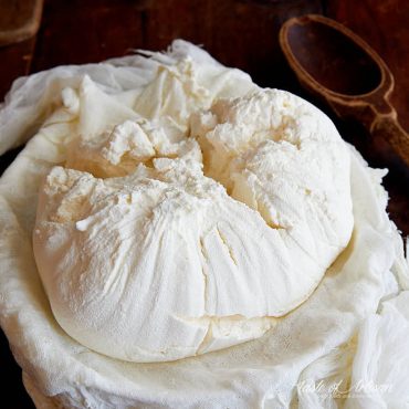 A bowl lined with muslin full of freshly made cream cheese.