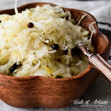 A bowl of homemade sauerkraut with a fork inserted.