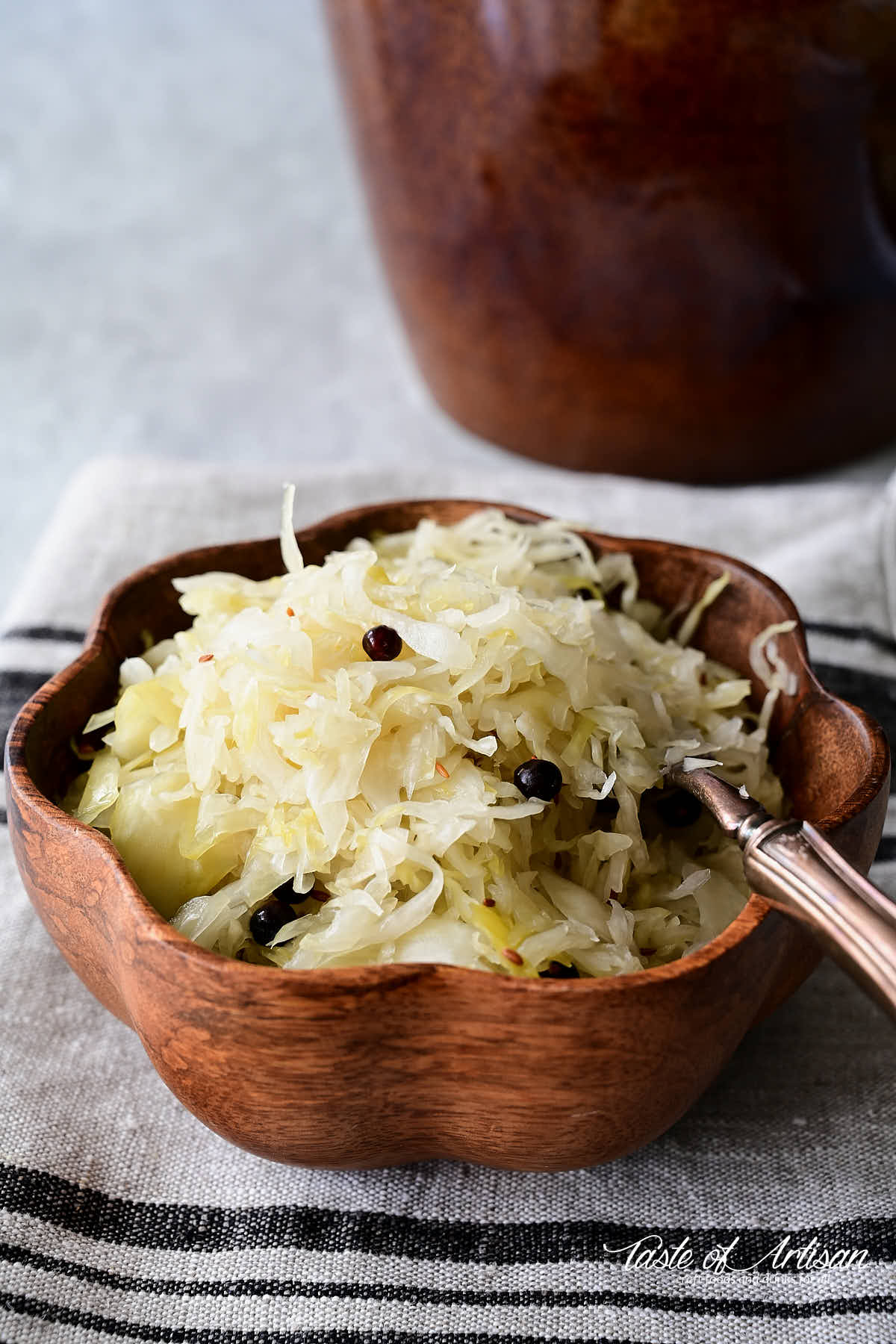 A bowl of homemade sauerkraut with a fork inserted.