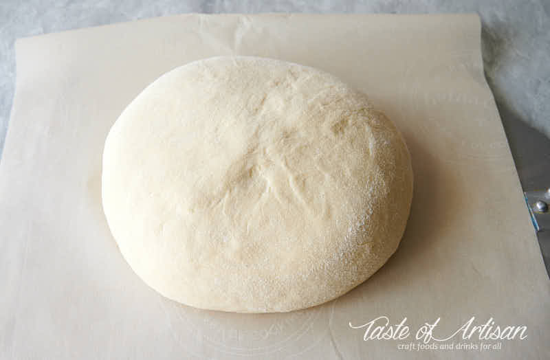 Bread dough turned over onto parchment paper.