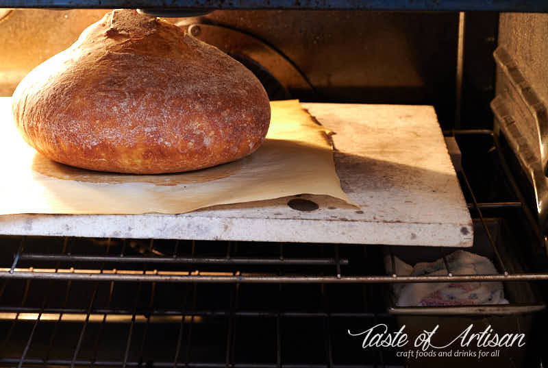 Bread baking in oven on pizza stone.