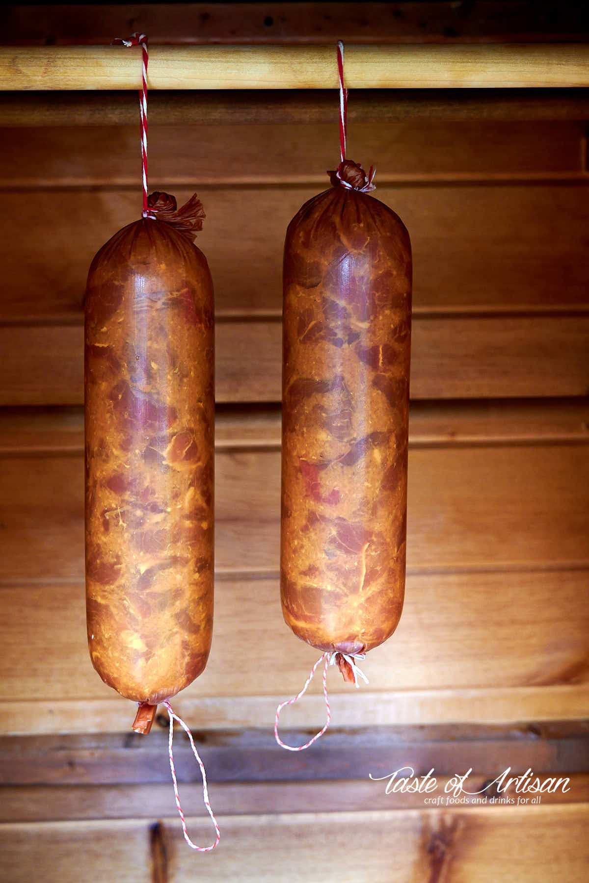 Krakow sausage hanging inside smokehouse, ready for smoking.