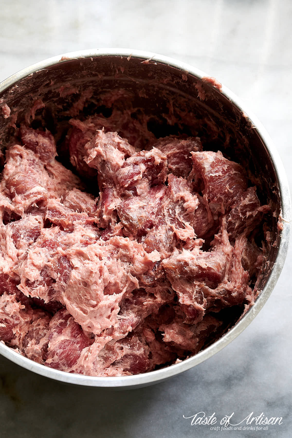 Mixed meat inside a bowl, ready to be stuffed to make Krakow sausage.