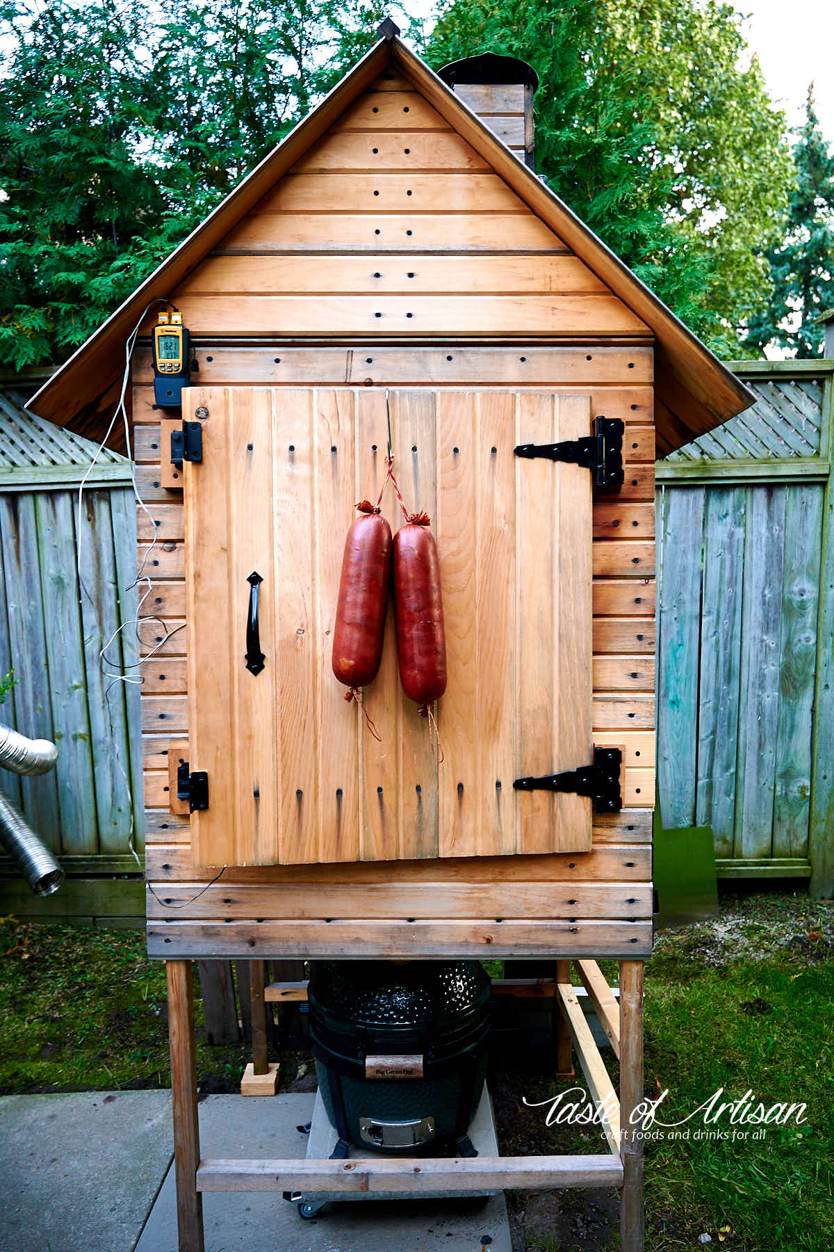 Krakow sausage hanging from the door of a smokehouse.